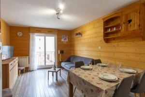 a living room with a table and a couch at Appartement centre ville parking balcon et wi fi in Cauterets