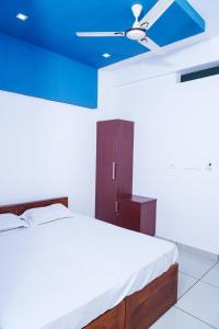 1 dormitorio con 1 cama con techo azul en THEKKUMPURAM RESIDENCY, en Kondotti