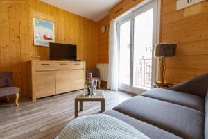 a living room with a couch and a tv at Appartement centre ville parking balcon et wi fi in Cauterets