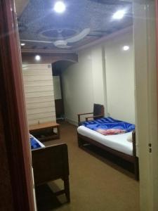 sypialnia z łóżkiem i sufitem z wentylatorem w obiekcie Hotel Deluxe w mieście Kachāhri