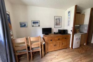 Habitación con escritorio, ordenador y 2 sillas. en Charming Studio In The Heart Of Saint Chaffrey, en Saint-Chaffrey