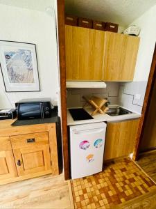 Una pequeña cocina con fregadero y estufa. en Charming Studio In The Heart Of Saint Chaffrey, en Saint-Chaffrey