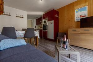 a living room with a couch and a kitchen with a table at Appartement centre ville parking balcon et wi fi in Cauterets