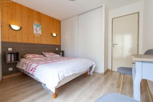 a bedroom with a bed and a wooden wall at Appartement centre ville parking balcon et wi fi in Cauterets