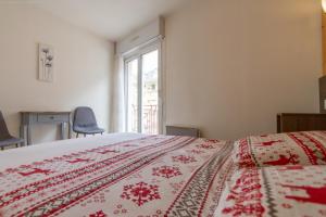 Appartement centre ville parking balcon et wi fi في كوتيريه: غرفة نوم بها سرير وبطانية حمراء +5 صور