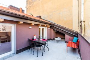 patio con mesa y sillas en el balcón en ALTIDO Contemporary apartments in historical Giambellino-Lorenteggio, en Milán