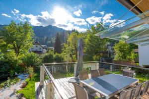 a patio with a table and chairs on a deck at Achen Appartement in Bad Hofgastein