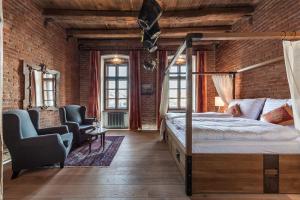 a bedroom with a bed and a brick wall at Hotel Mariánský Dvůr in Uherské Hradiště