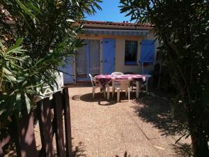 un patio con tavolo e sedie di fronte a una casa di Maison Argeles sur mer proche plage ad Argelès-sur-Mer