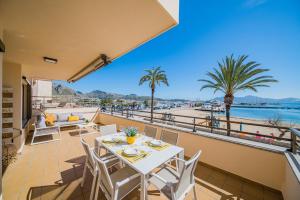 ein Balkon mit Tisch und Stühlen und Blick auf das Wasser in der Unterkunft Cana Ferrera in Port de Pollença