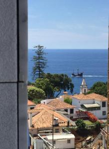 a large ship in the ocean next to a city at Astro Madeira Apartments in Funchal
