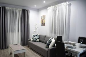 sala de estar con sofá y mesa en Alojamientos Lola, Suite con jacuzzi, en Benalup-Casas Viejas