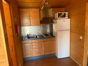 a small kitchen with a refrigerator and a microwave at Casinha do Rogel in Alcantarilha