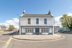 a white building on the corner of a street at The Ship Inn in Musselburgh