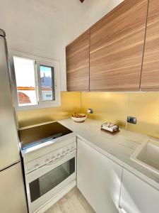una cocina con encimeras blancas y armarios de madera en La Casita de la Parra, El Hierro, en Tamaduste