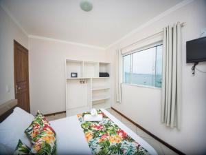 mały pokój z łóżkiem i oknem w obiekcie Hotel Monteiro Canasvieiras w mieście Florianópolis