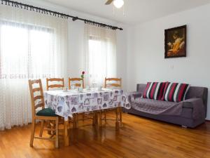 a dining room with a table and chairs and a couch at Apartment Vera - MLK325 by Interhome in Malinska