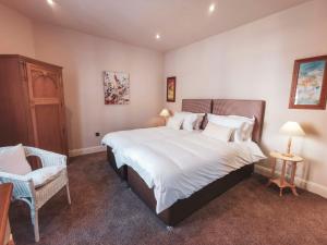 een slaapkamer met een groot wit bed en een stoel bij The Ship Inn in Musselburgh