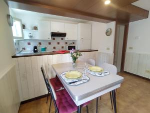 a kitchen with a white table with two plates on it at Apartment Giardino by Interhome in Porlezza