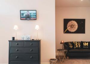 a living room with a black dresser and a couch at The Ship Inn in Musselburgh