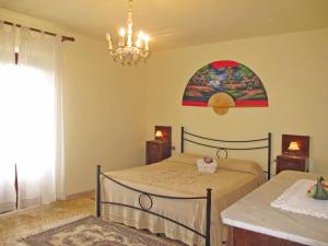 CannetoにあるLocazione Turistica L'Uccelliera - SMN132のベッドルーム1室(ベッド1台付)が備わります。壁には絵画が飾られています。