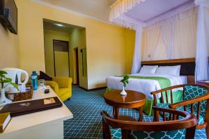 um quarto de hotel com uma cama, uma mesa e cadeiras em Rift Valley Hills Resort em Kabarnet