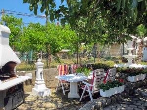 uma mesa e cadeiras num jardim com um fogão em Apartment Dilly - KRK117 by Interhome em Pinezici