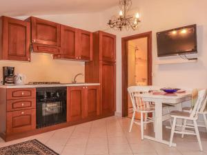 une cuisine avec des placards en bois et une table ainsi qu'une salle à manger dans l'établissement Apartment Dilly - KRK117 by Interhome, à Pinezići