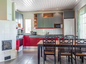 una cocina con armarios rojos y una mesa con sillas. en Holiday Home Hintrekki by Interhome, en Kaustinen