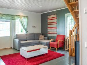 ein Wohnzimmer mit einem Sofa und einem roten Teppich in der Unterkunft Holiday Home Hintrekki by Interhome in Kaustinen