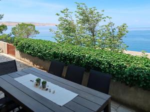 a wooden table and chairs with a view of the ocean at Holiday Home Mara - KBG400 by Interhome in Matijević