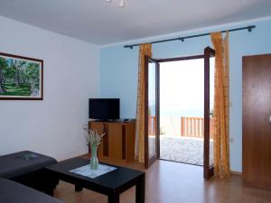 ein Wohnzimmer mit einem Sofa und einer Glasschiebetür in der Unterkunft Holiday Home Mara - KBG400 by Interhome in Matijević