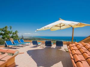 a patio with chairs and an umbrella and the ocean at Villa Von Salis by Interhome in Ansedónia