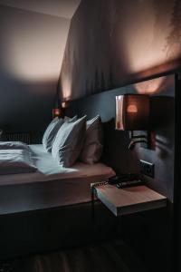 a hotel room with a bed with a lamp and a table at The HEY HOTEL in Interlaken