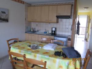 a kitchen with a table and chairs in a room at T3 avec balcon plein sud en bord de mer – 50 ml .2 chambres tout confort, équipé de chauffage électrique pour période hivernale, in Camiers