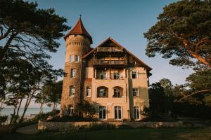 stary dom z wieżą na górze w obiekcie Zamek Łeba Resort & Spa w Łebie