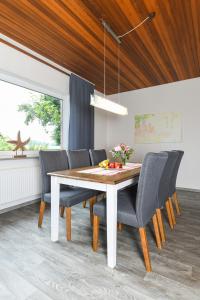 ein Esszimmer mit einem weißen Tisch und Stühlen in der Unterkunft Ferienhaus Nordseeruhe in Wangerland