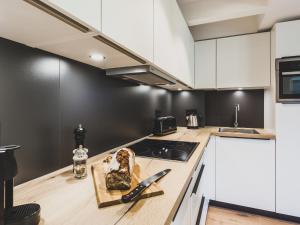 een keuken met witte kasten en een aanrecht bij Apartment Mariandl am Meer-5 by Interhome in Staphel