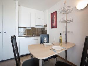 a kitchen with a table with two glasses of wine at Studio Combire 405 by Interhome in Les Collons