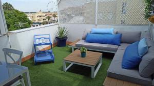 a patio with couches and a table on a balcony at Ático con Encanto in Sanlúcar de Barrameda