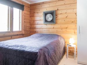 ein Schlafzimmer mit einem Bett in einer Holzwand in der Unterkunft Holiday Home Tinttityy by Interhome in Tahkovuori