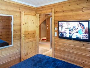 Zimmer mit einem TV an einer Holzwand in der Unterkunft Holiday Home Tinttityy by Interhome in Tahkovuori