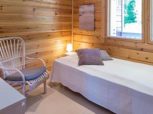 ein Schlafzimmer mit einem Bett, einem Stuhl und einem Fenster in der Unterkunft Holiday Home Tinttityy by Interhome in Tahkovuori