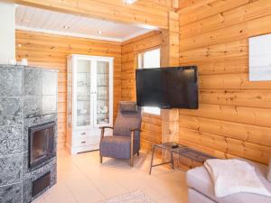 ein Wohnzimmer mit einem Kamin und einem Flachbild-TV in der Unterkunft Holiday Home Tinttityy by Interhome in Tahkovuori