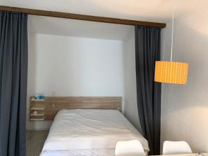 a bedroom with a bed and a lamp and chairs at Apartment Parkareal - Utoring-21 by Interhome in Bolgen