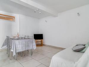 ein Wohnzimmer mit einem Tisch und einem TV in der Unterkunft Apartment Les Chevrefeuilles by Interhome in La Valette-du-Var