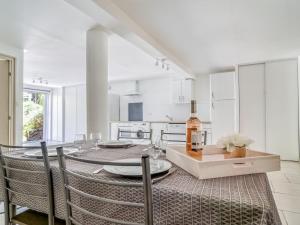 a white kitchen with a table with a bottle of wine at Apartment Les Chevrefeuilles by Interhome in La Valette-du-Var