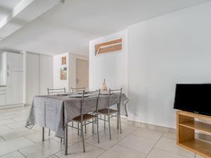 a dining room with a table and chairs and a tv at Apartment Les Chevrefeuilles by Interhome in La Valette-du-Var