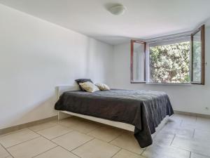 Schlafzimmer mit einem Bett und einem Fenster in der Unterkunft Apartment Les Chevrefeuilles by Interhome in La Valette-du-Var