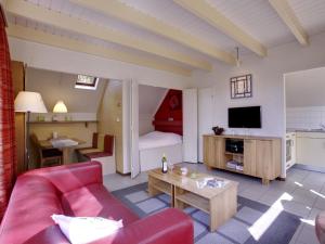 - un salon avec un canapé rouge et une table dans l'établissement Holiday Home Buitenplaats Gerner-8 by Interhome, à Dalfsen